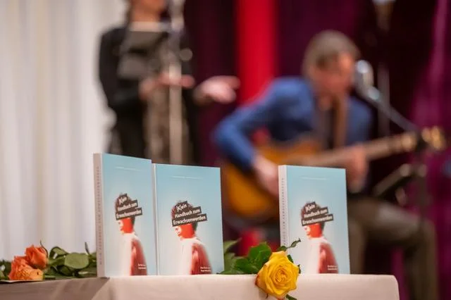 Jugendweihe-Bücher und Rosen vor Musikern auf der Bühne